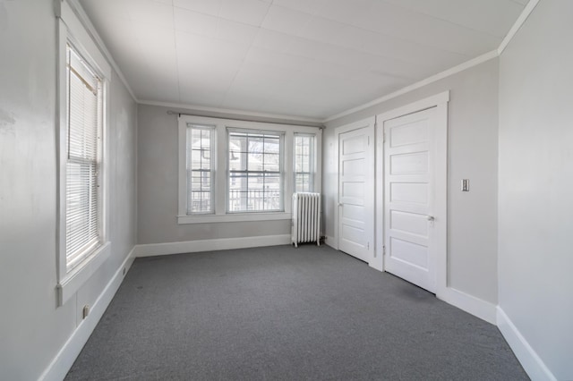 unfurnished bedroom featuring radiator, ornamental molding, and dark colored carpet