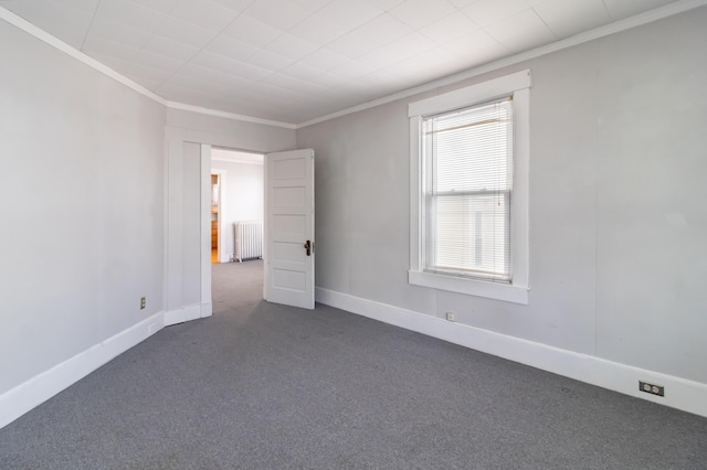 carpeted empty room with crown molding and radiator