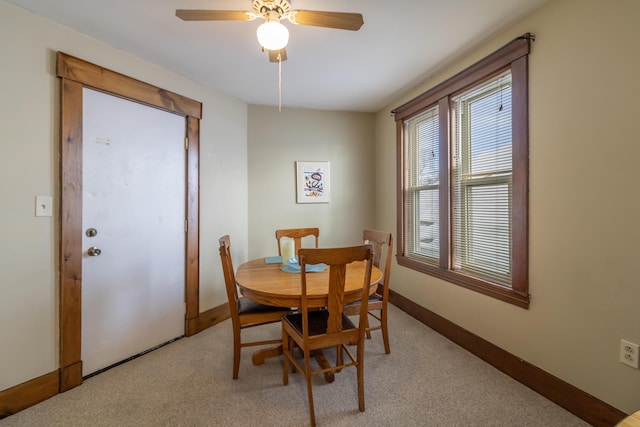 carpeted dining area with ceiling fan