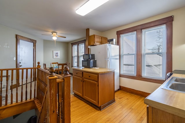 kitchen with ceiling fan, sink, white fridge, and light wood-type flooring