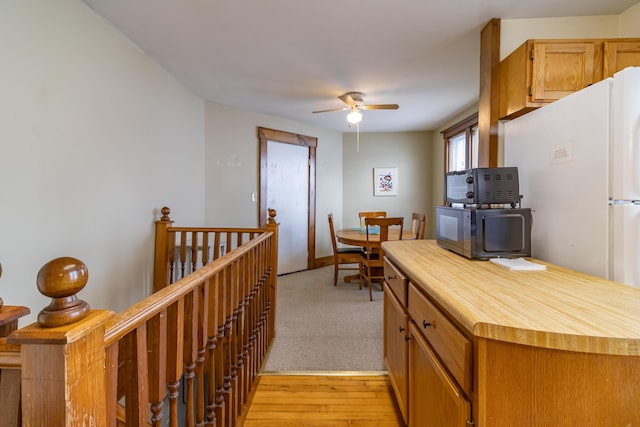 kitchen with ceiling fan and light hardwood / wood-style flooring