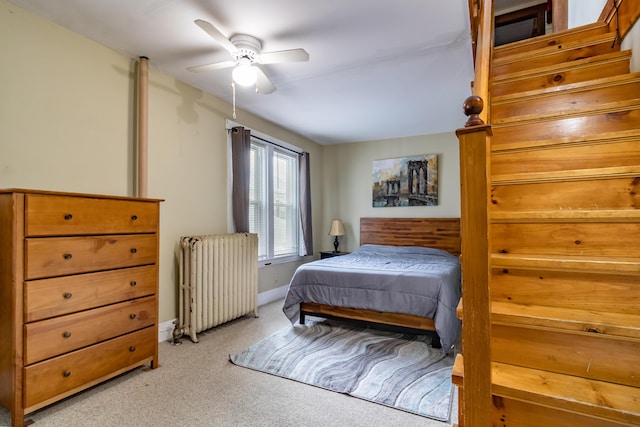 bedroom featuring light carpet, radiator heating unit, and ceiling fan