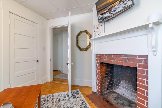 living room featuring wood-type flooring and a brick fireplace