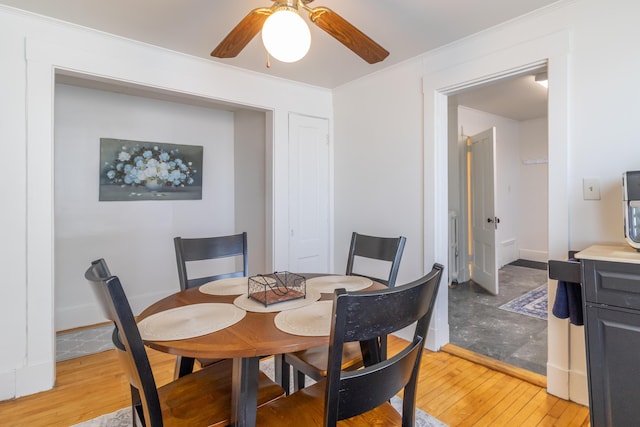 dining area featuring ornamental molding, ceiling fan, and light hardwood / wood-style floors