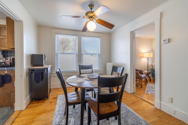 dining area featuring ornamental molding, light hardwood / wood-style floors, and ceiling fan