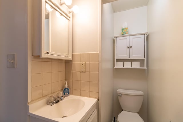 bathroom featuring tasteful backsplash, vanity, and toilet