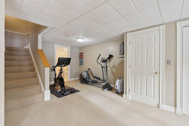 workout room featuring carpet floors and a drop ceiling