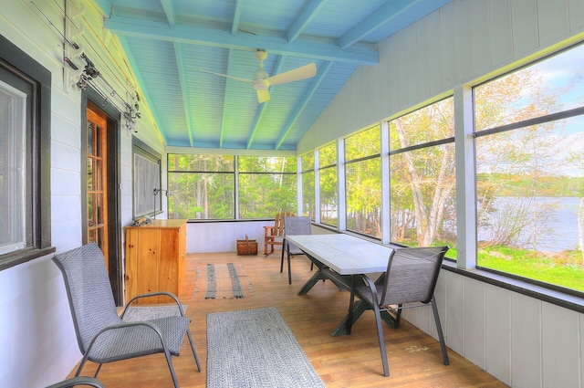 sunroom featuring lofted ceiling with beams and a ceiling fan