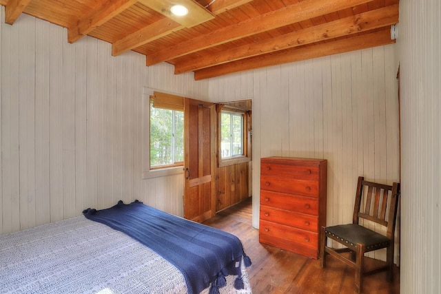 bedroom featuring dark wood-type flooring, beam ceiling, wooden ceiling, and wood walls