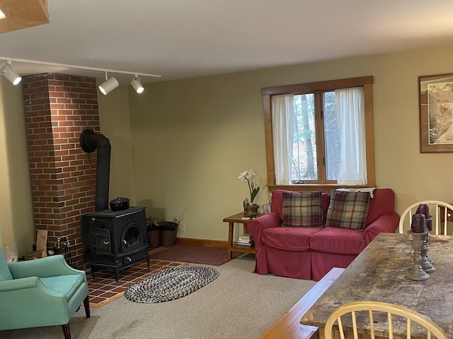 carpeted living room with track lighting and a wood stove