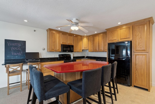 kitchen with sink, a textured ceiling, a kitchen island, ceiling fan, and black appliances