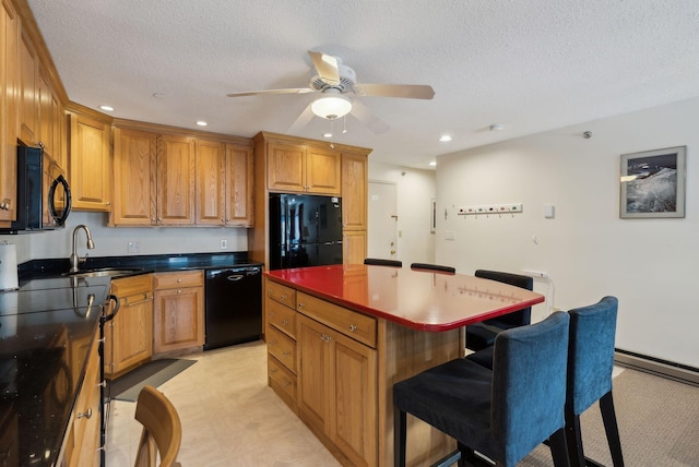 kitchen featuring sink, black appliances, a textured ceiling, and a kitchen island