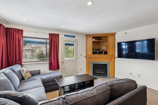 living room with carpet flooring, a tile fireplace, and a textured ceiling