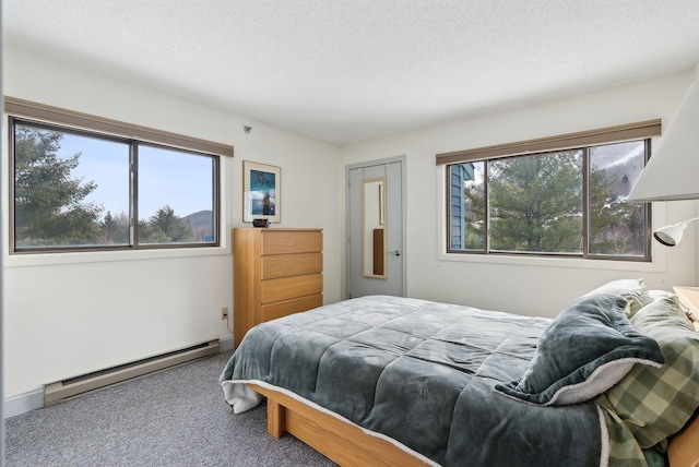 carpeted bedroom with multiple windows, a baseboard radiator, and a textured ceiling