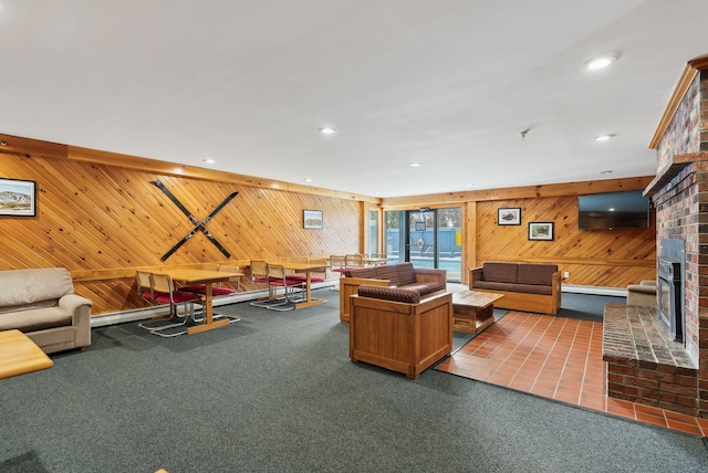 carpeted living room with a fireplace and wooden walls