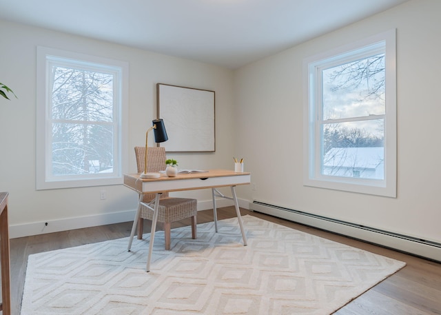 office area featuring a baseboard radiator, plenty of natural light, and light wood-type flooring