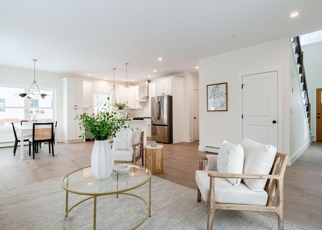 living room with light hardwood / wood-style flooring and a baseboard heating unit