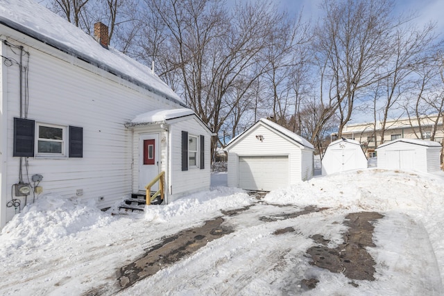 view of front of home featuring a garage, entry steps, an outdoor structure, and a storage shed