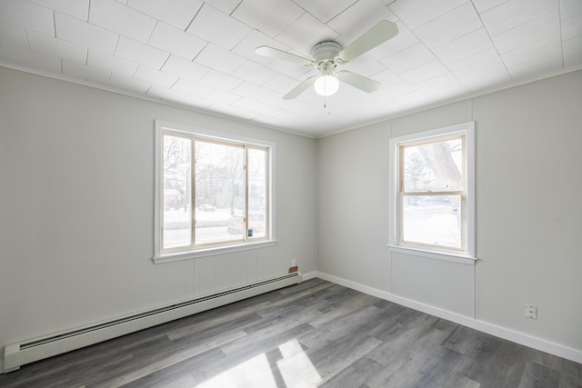 spare room with ceiling fan, baseboards, baseboard heating, and wood finished floors