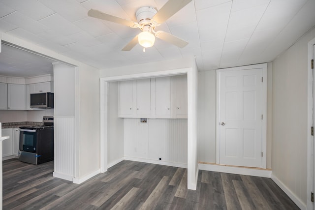 laundry area featuring a ceiling fan, dark wood finished floors, and baseboards