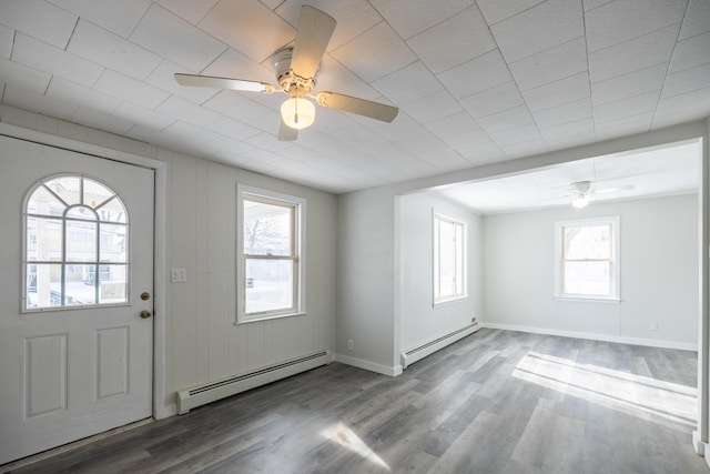 foyer entrance featuring a baseboard heating unit, a ceiling fan, baseboards, and wood finished floors