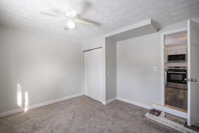 unfurnished bedroom with baseboards, a ceiling fan, carpet, a textured ceiling, and a closet