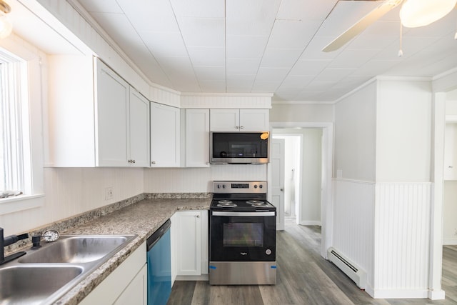 kitchen with dark wood-type flooring, stainless steel appliances, a baseboard heating unit, white cabinetry, and a sink