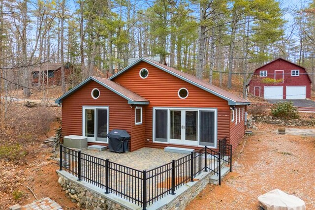 48 Green Bay Rd, Newfield, ME 04095 - rear view of property with log veneer siding, french doors, and a garage