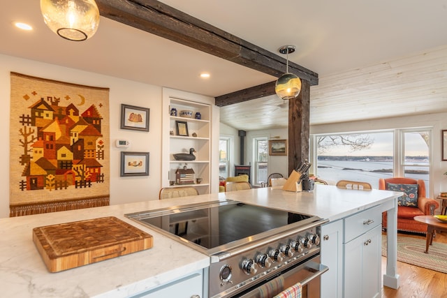 kitchen with light wood-type flooring, light stone counters, decorative light fixtures, recessed lighting, and stove