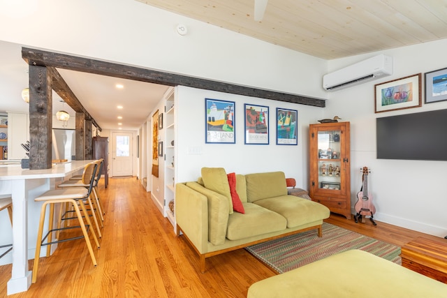 living area featuring an AC wall unit, recessed lighting, light wood-style floors, and baseboards