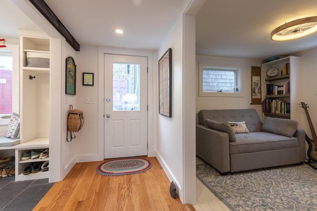 entryway with baseboards and light wood finished floors