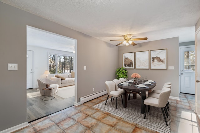 dining space with a baseboard radiator, a healthy amount of sunlight, ceiling fan, and a textured ceiling