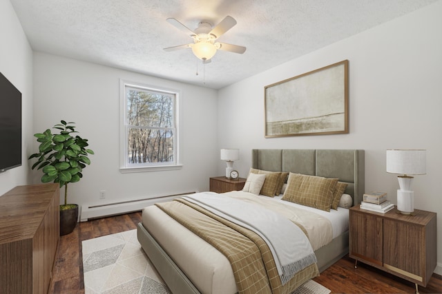 bedroom with ceiling fan, dark wood-type flooring, a baseboard radiator, and a textured ceiling