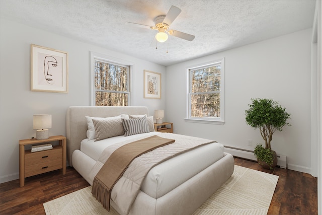 bedroom featuring dark wood-type flooring, a textured ceiling, and baseboard heating