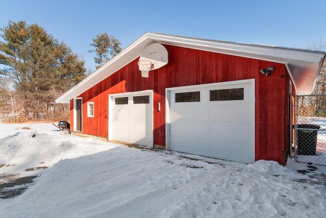 snow covered garage featuring cooling unit