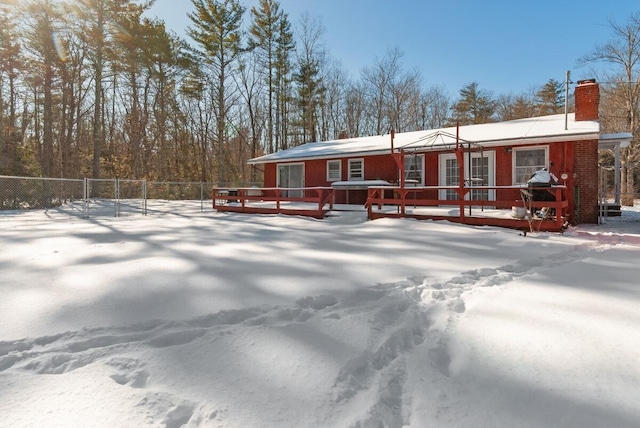 snow covered property with a deck