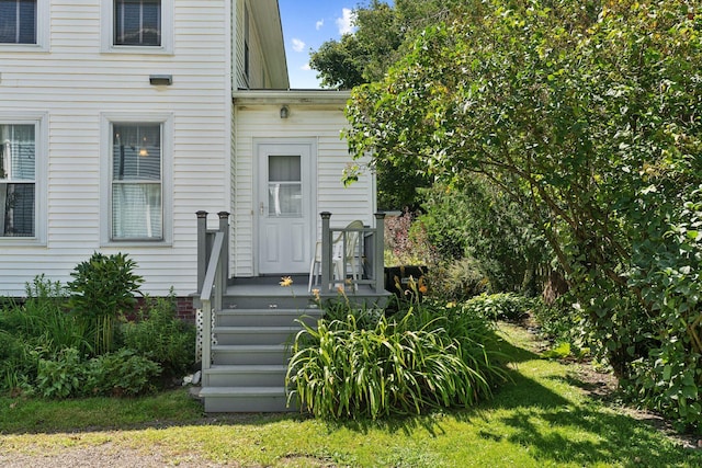 doorway to property with a lawn