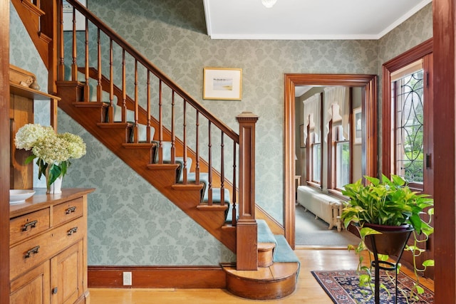 entrance foyer featuring radiator, light hardwood / wood-style flooring, and ornamental molding