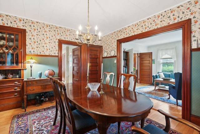 dining space featuring light hardwood / wood-style floors and a notable chandelier