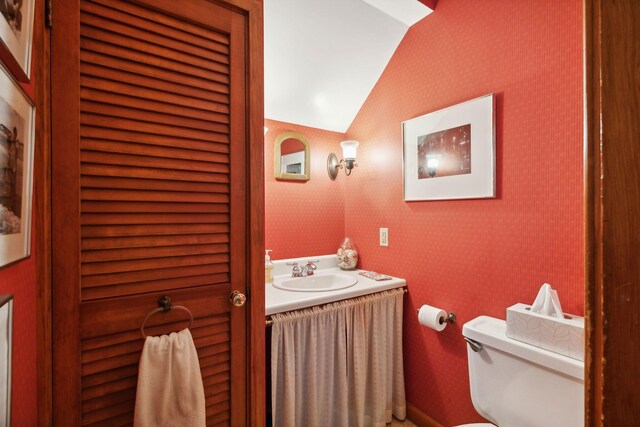 bathroom featuring vaulted ceiling, vanity, and toilet