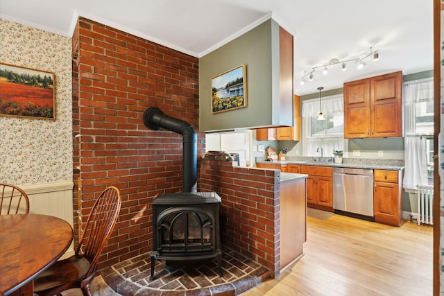 kitchen featuring a wood stove, dishwasher, pendant lighting, light stone countertops, and light hardwood / wood-style floors