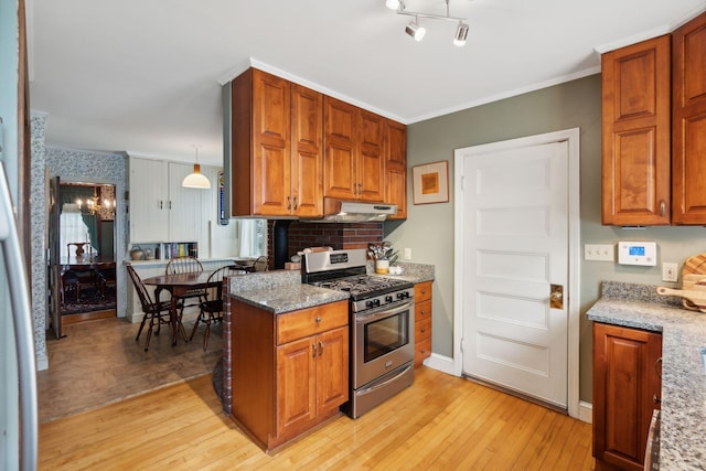 kitchen featuring pendant lighting, crown molding, light hardwood / wood-style flooring, stainless steel range with gas stovetop, and stone countertops