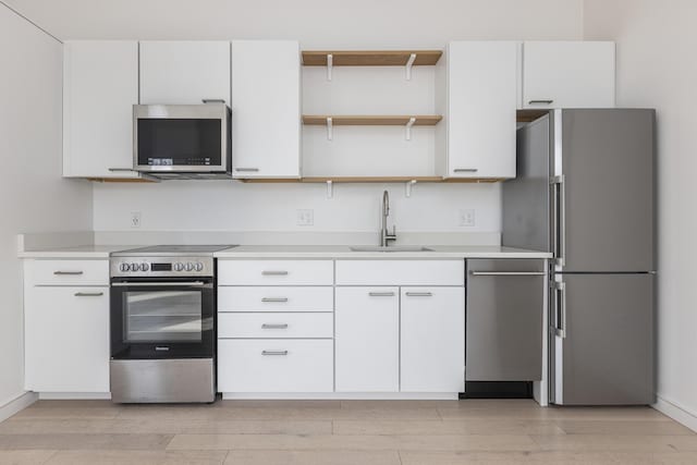 kitchen with white cabinetry, stainless steel appliances, and sink