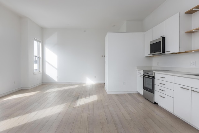 kitchen featuring white cabinetry, stainless steel appliances, and light hardwood / wood-style flooring