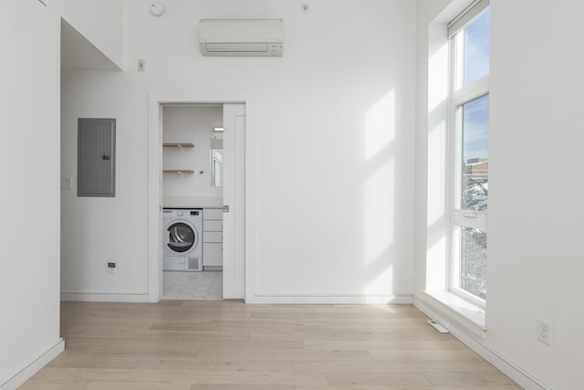 laundry room featuring washer / clothes dryer, a wealth of natural light, electric panel, and a wall mounted AC