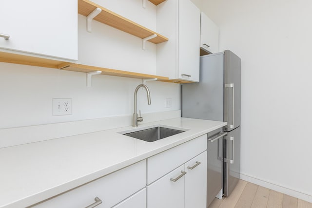 1 Joy Pl Unit 3A, Portland, ME 04102 - kitchen with open shelves, light wood-type flooring, light countertops, white cabinets, and a sink