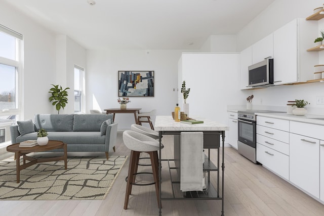 1 Joy Pl Unit 3A, Portland, ME 04102 - kitchen featuring light countertops, open shelves, stainless steel appliances, and light wood-style flooring