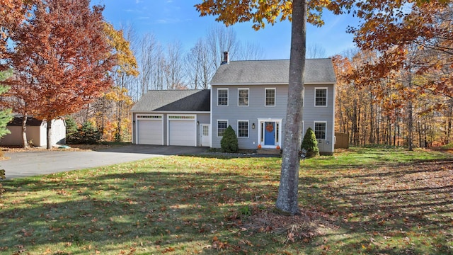 view of front facade featuring a garage, a front yard, and a storage unit