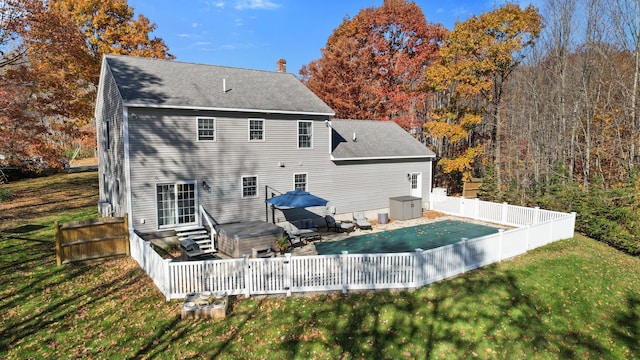 rear view of property featuring a swimming pool with hot tub, a yard, and a patio area