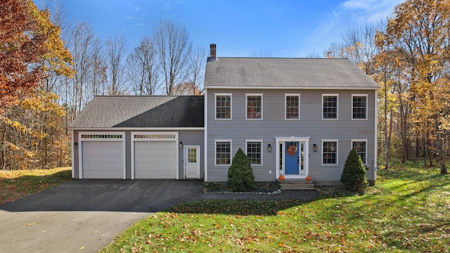 colonial home with a garage and a front yard